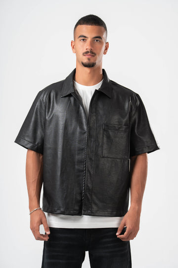 Man wearing a black leather shirt over a white t-shirt on a white background