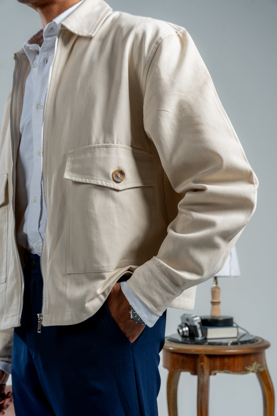 Person wearing a beige jacket with a neutral background