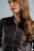 Woman wearing a brown leather jacket with a gray background