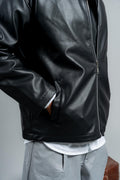 Black leather jacket worn by a person on a plain background