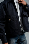 Person wearing a dark blue jacket with a blurred background