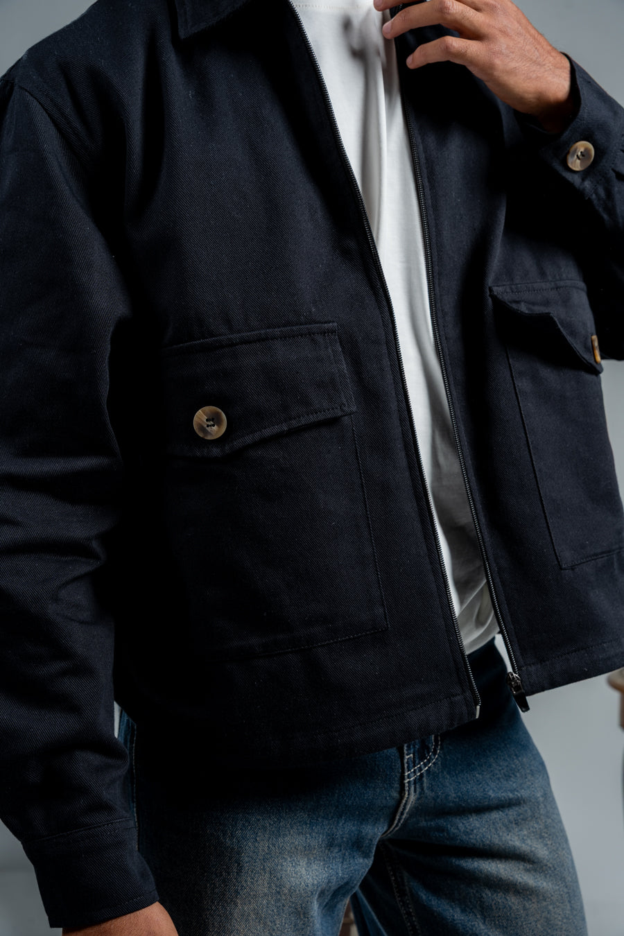 Person wearing a dark blue jacket with a blurred background