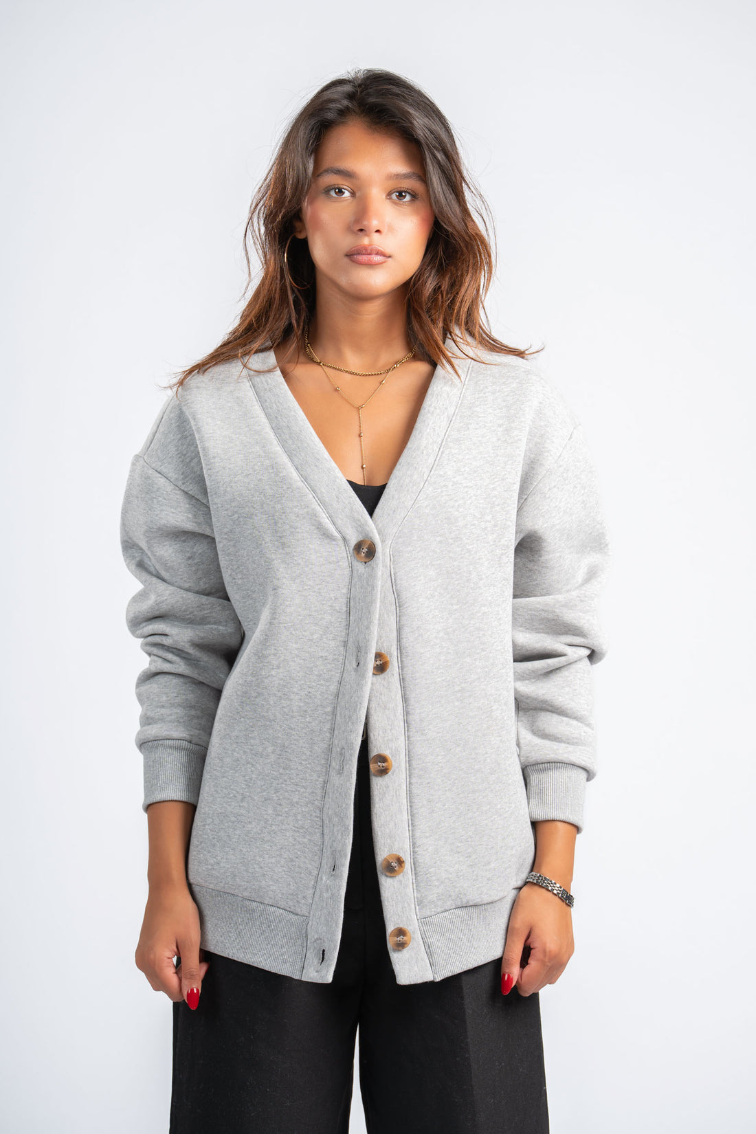 Woman wearing a gray cardigan on a white background