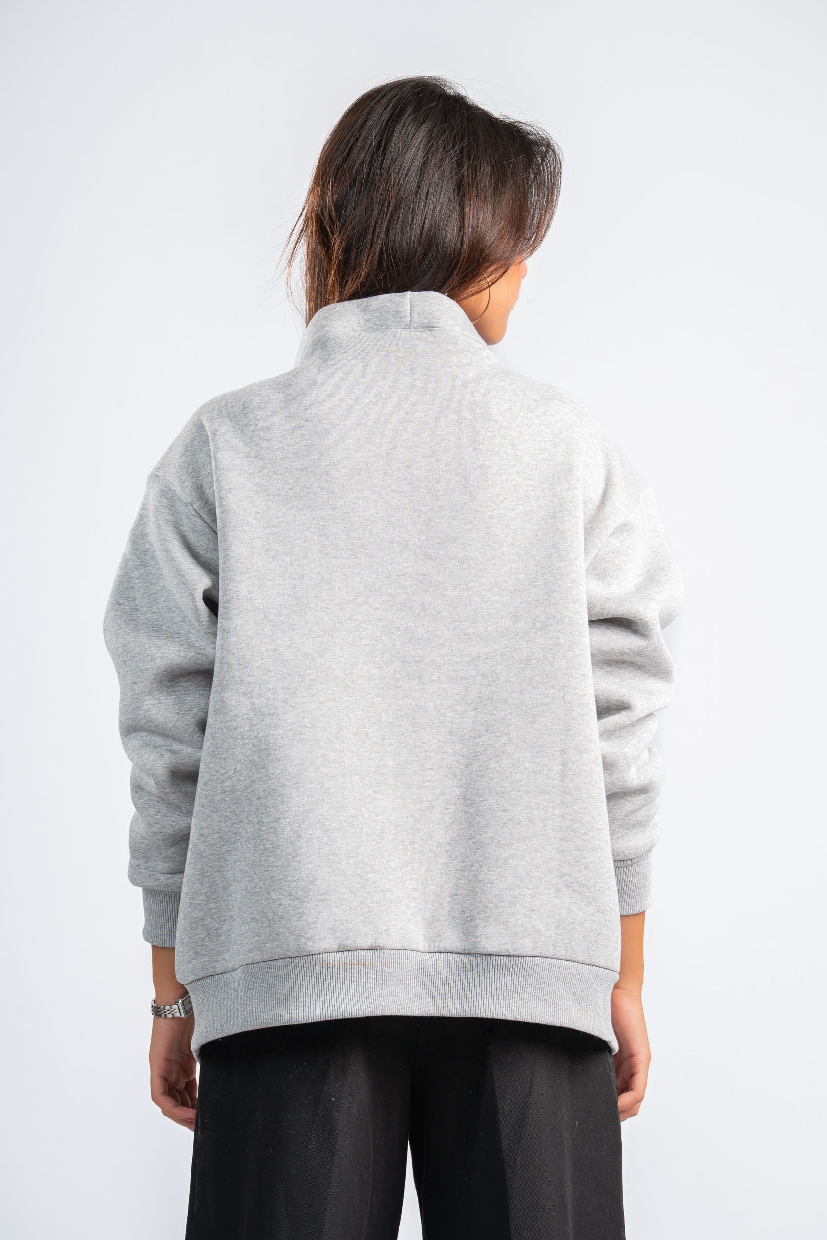 Person wearing a gray jacket on a white background