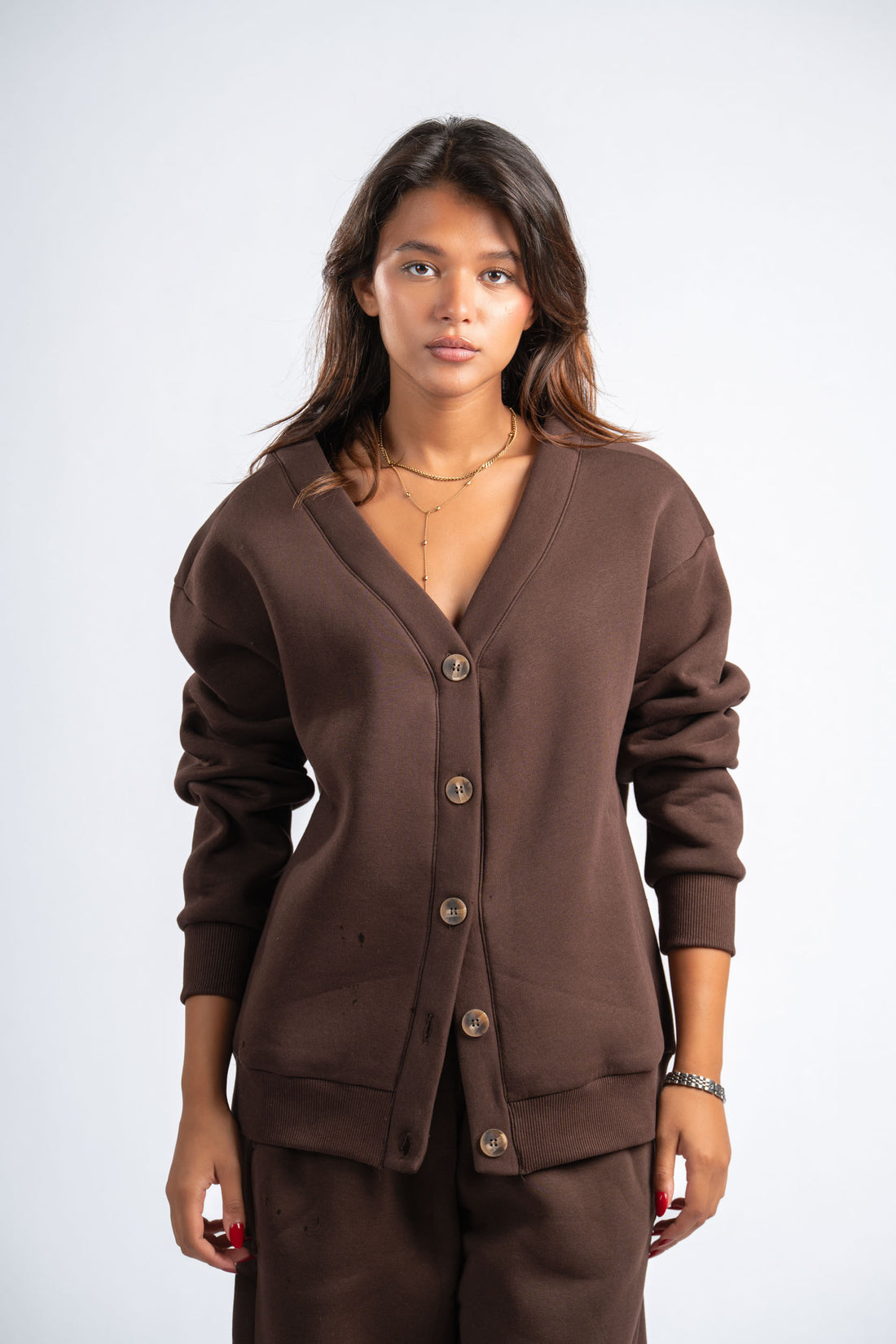Woman wearing a brown cardigan and pants on a white background