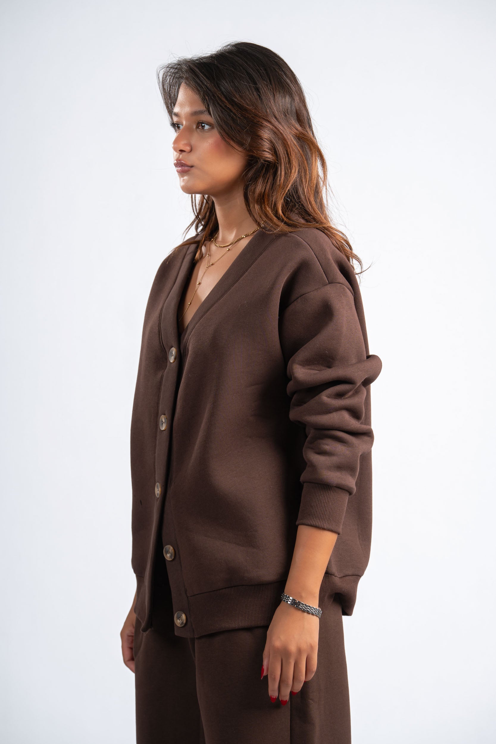 Woman wearing a brown cardigan and pants on a white background