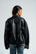 Person wearing a black leather jacket on a plain background