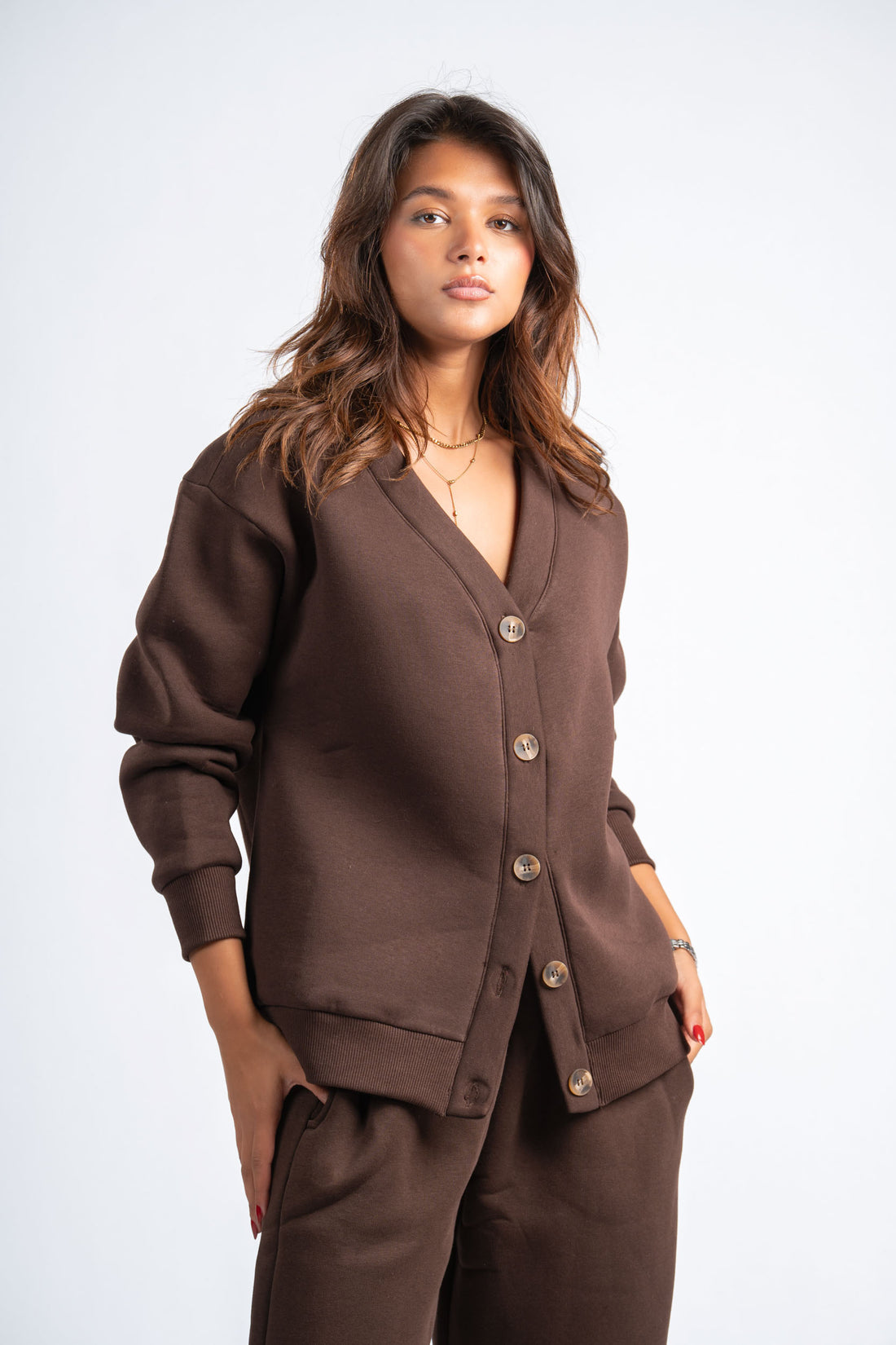 Woman wearing a brown cardigan and pants on a white background
