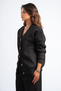 Woman wearing a black blazer against a white background
