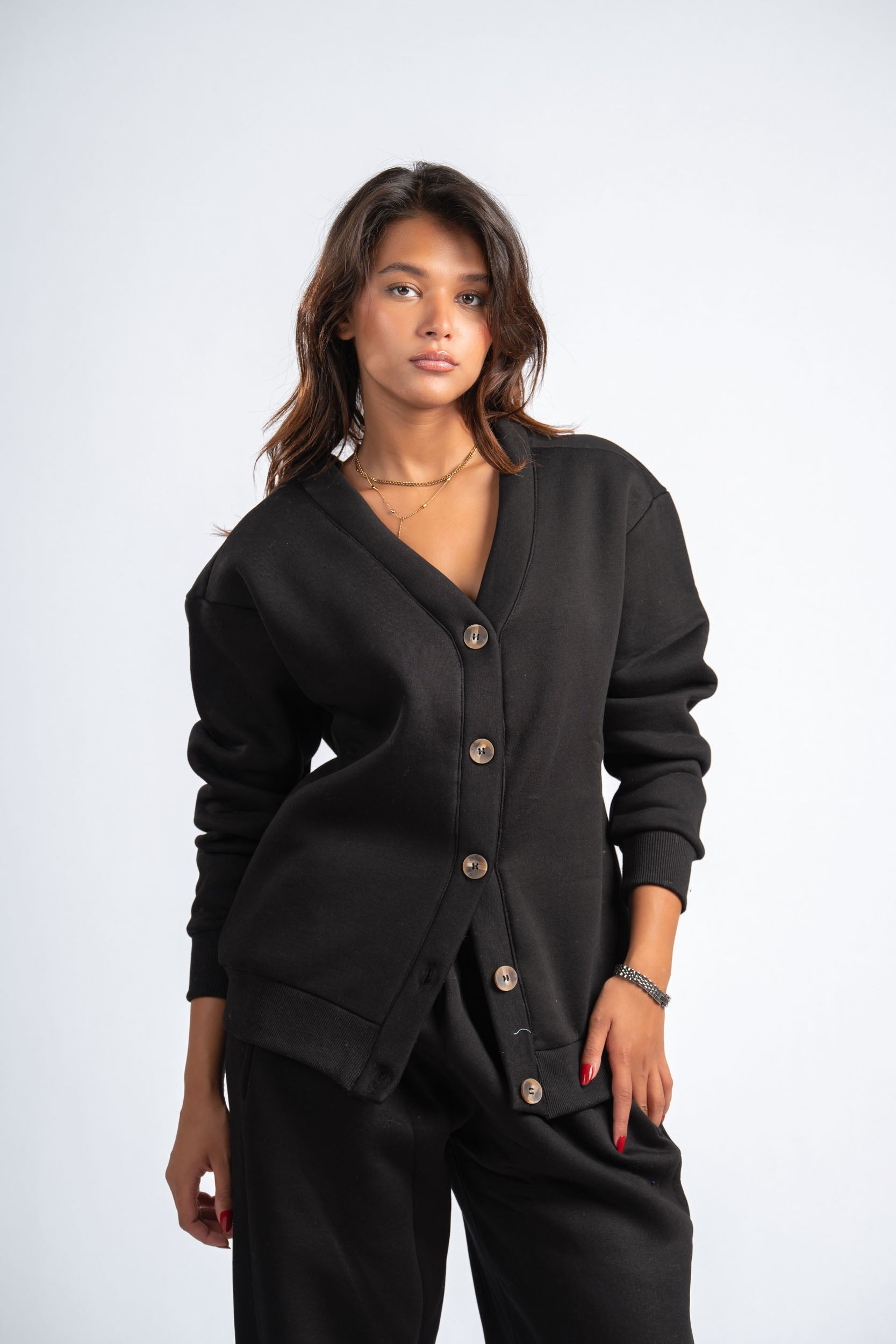 Woman wearing a black cardigan with buttons on a white background