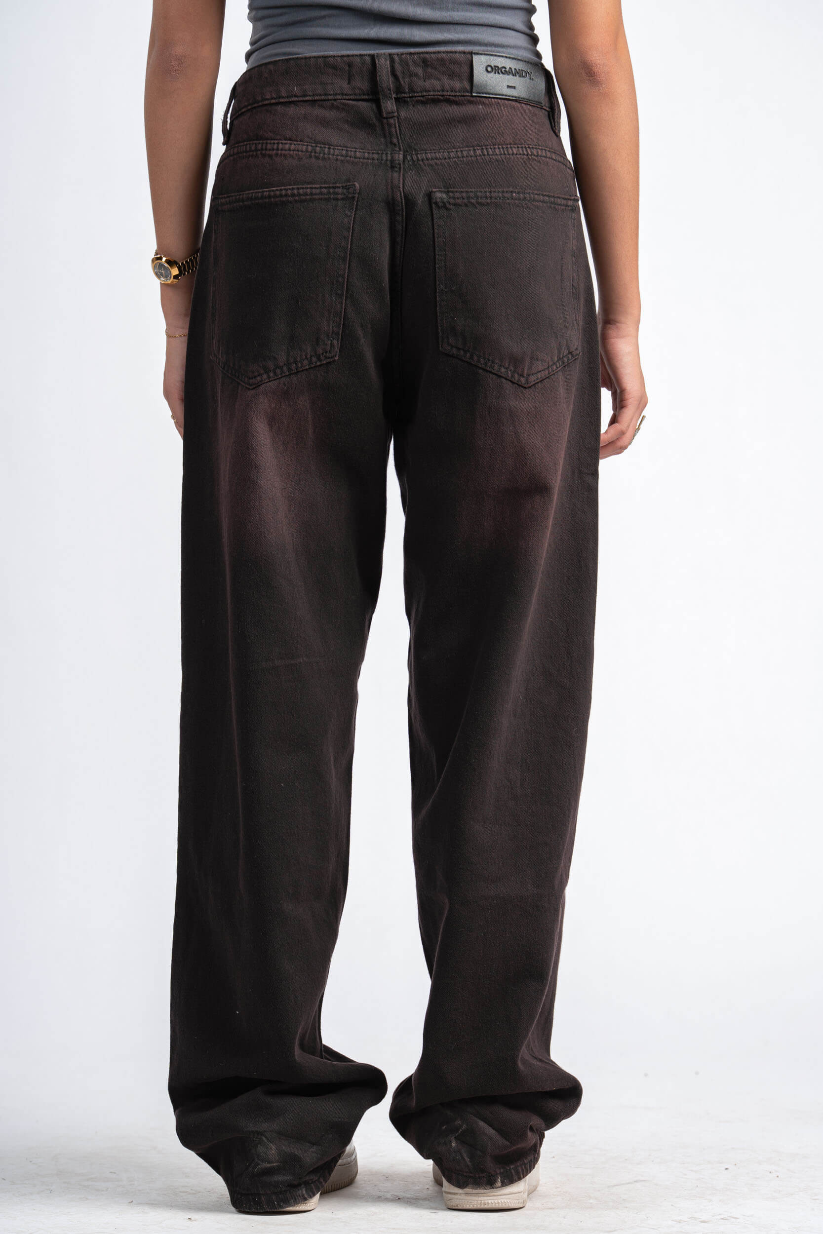 Brown pants worn by a person on a white background