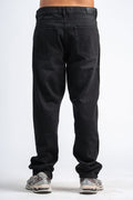 Black jeans worn by a person on a white background