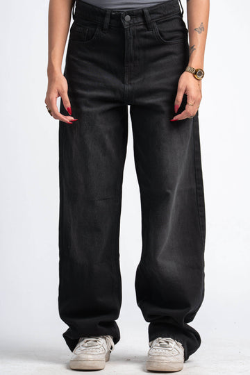 Person wearing black wide-leg jeans on a white background