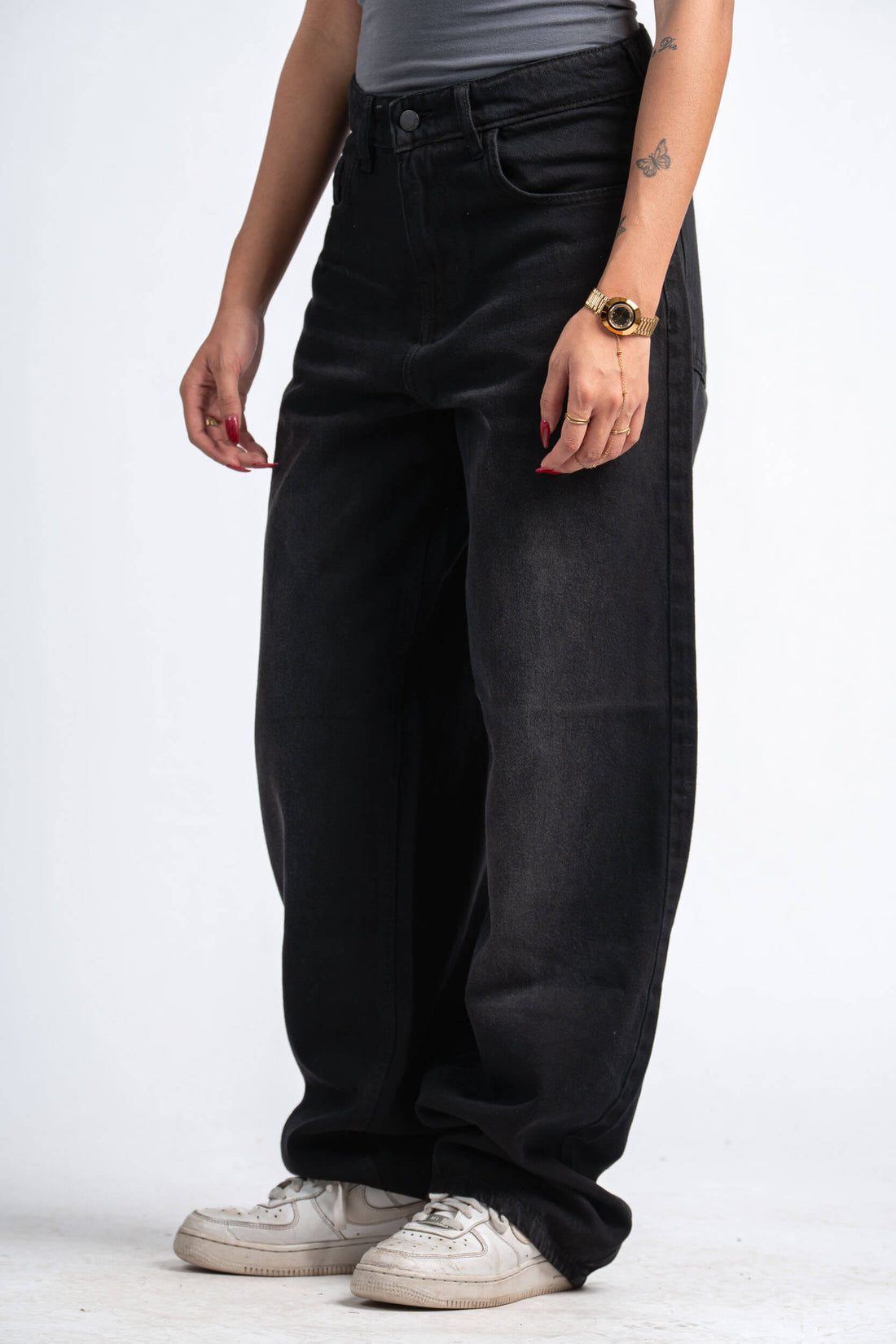 Person wearing black wide-leg jeans on a white background