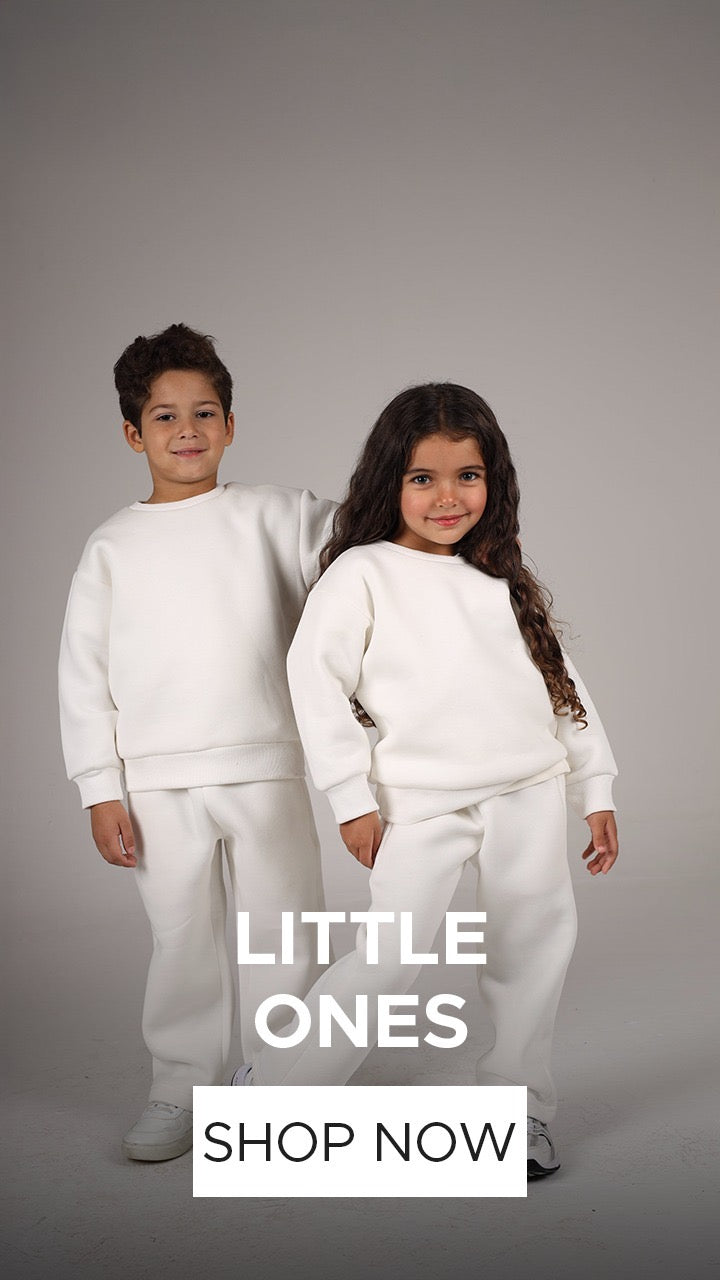 Two children wearing matching white outfits with text 'Little Ones' and 'Shop Now' on a gray background.