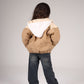 Person wearing a beige and white jacket on a plain background