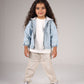 Child wearing a light blue denim jacket, white shirt, beige pants, and sneakers on a gray background