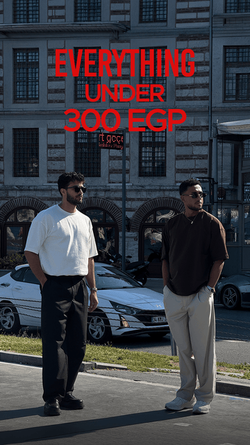 Two men standing outdoors in front of a building with large windows and parked cars, with bold red text reading 'EVERYTHING UNDER 300 EGP' across the top.