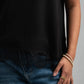Person wearing a black t-shirt and blue jeans with a neutral background