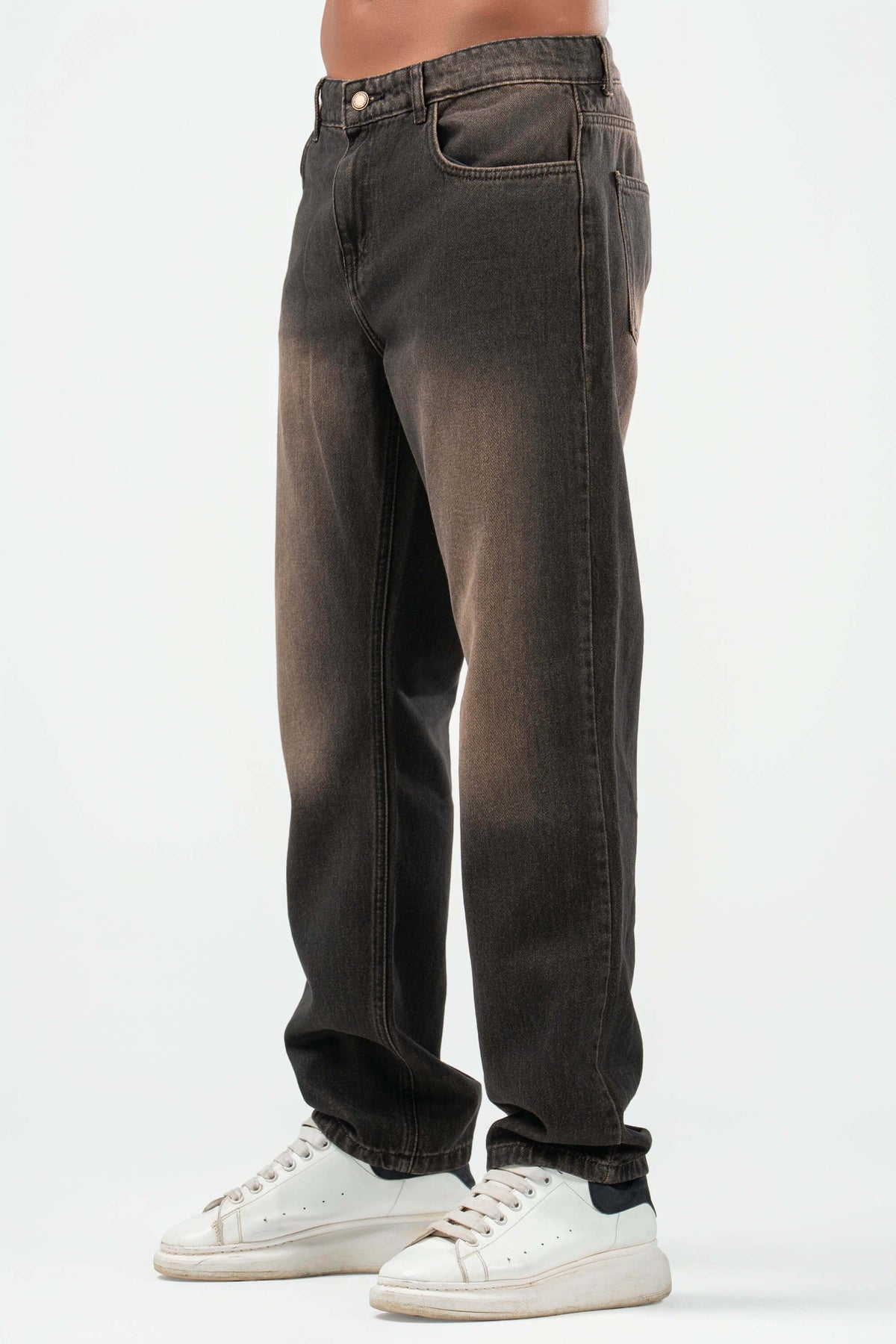 Dark jeans worn by a person on a white background