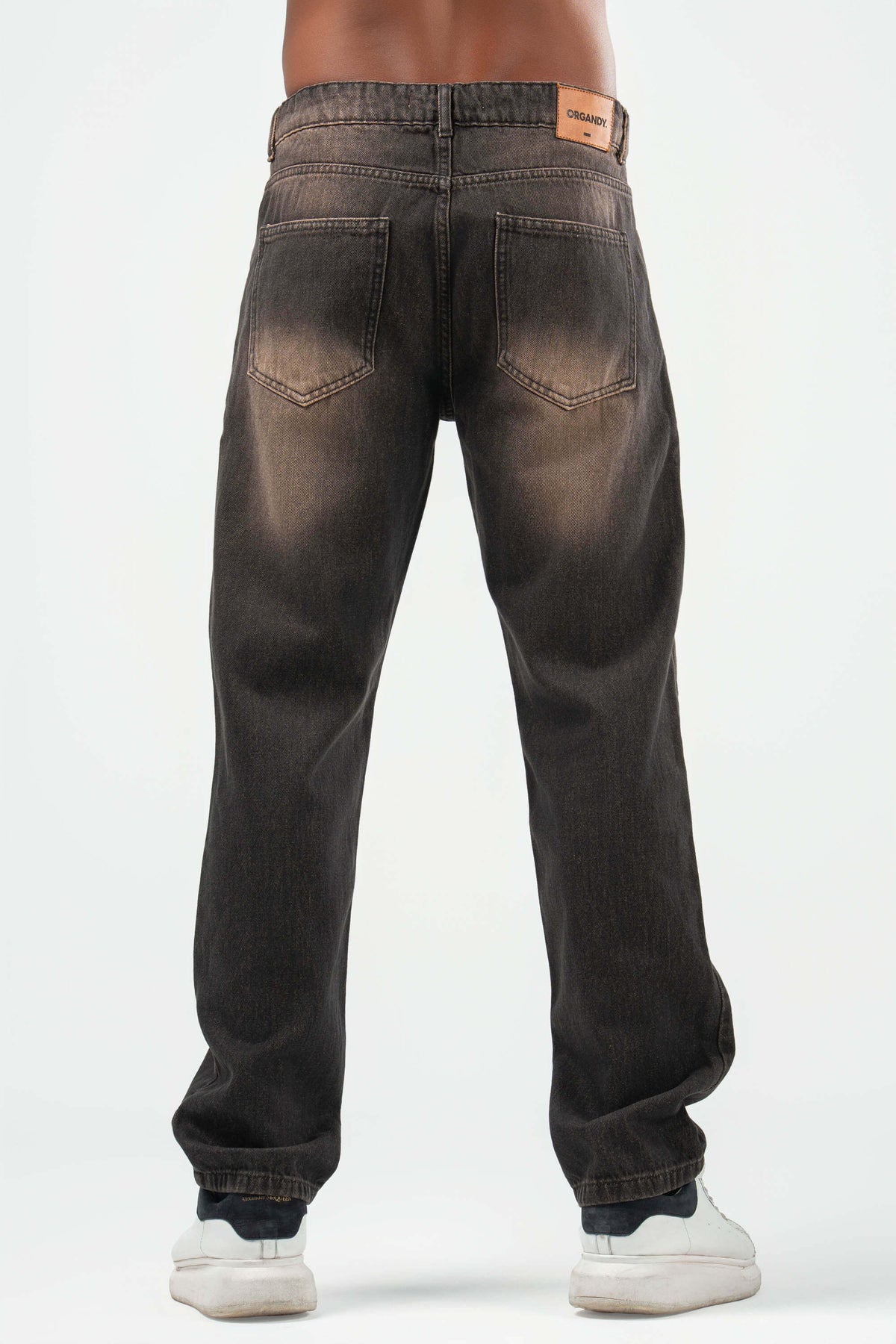 Dark jeans worn by a person on a white background