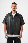 Man wearing a black leather shirt over a white t-shirt on a white background
