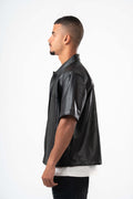 Man wearing a black leather shirt on a white background