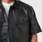Black leather shirt worn by a person on a white background