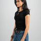 Woman wearing a black top and blue jeans on a gray background