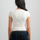 Person wearing a white t-shirt and dark jeans on a plain background