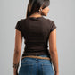 Person wearing a brown top and blue jeans on a gray background