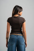 Person wearing a brown top and blue jeans on a gray background