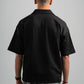 Person wearing a black polo shirt on a gray background