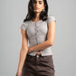 Woman wearing a gray t-shirt and brown pants against a gray background