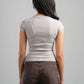 Person wearing a light gray t-shirt and brown pants against a gray background