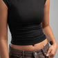 Person wearing a black sleeveless top and brown pants on a gray background