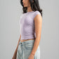 Woman wearing a light purple crop top and light blue jeans against a gray background