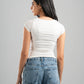 Woman wearing a white t-shirt and blue jeans against a gray background