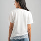 Person wearing a white t-shirt and blue jeans with lace trim on a gray background