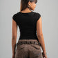 Woman wearing a black top and brown pants with floral patterns on a gray background