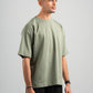 Man wearing a green t-shirt and black pants on a gray background