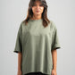 Woman wearing a green t-shirt against a gray background