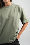 Person wearing a green t-shirt against a plain background