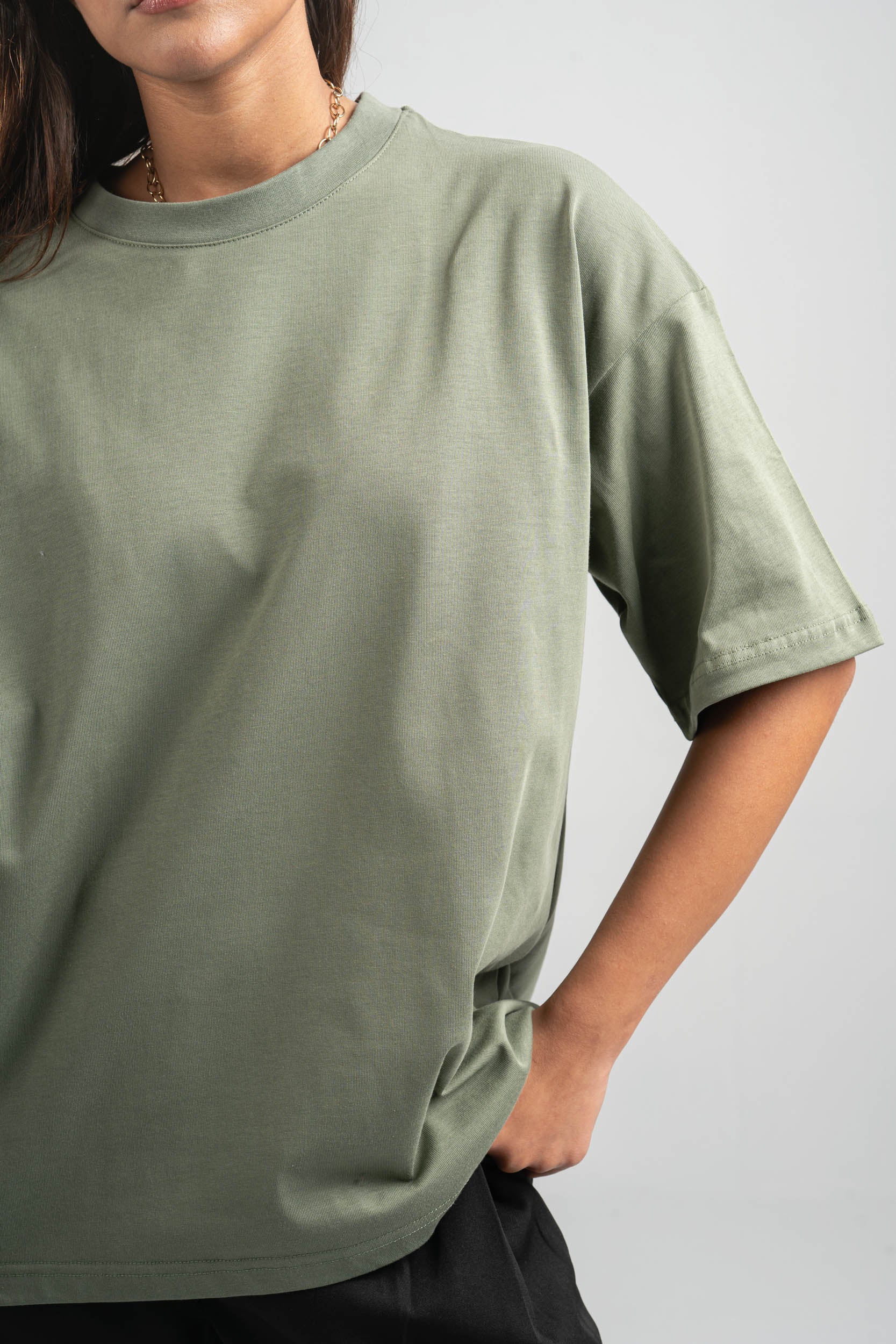 Person wearing a green t-shirt against a plain background
