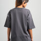 Person wearing a gray oversized t-shirt on a plain background