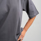 Person wearing a plain gray t-shirt against a light gray background