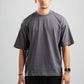 Man wearing a plain gray t-shirt and black pants on a light gray background