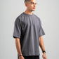 Man wearing a gray t-shirt and black pants on a light gray background