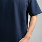 Person wearing a navy blue t-shirt on a gray background