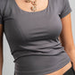 Gray t-shirt worn by a person with a gold necklace on a gray background
